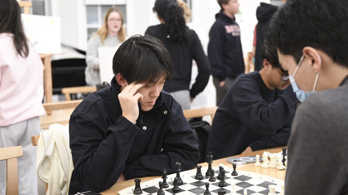 Fanou Zhang 24 and Daniel Zhang 24, members of the Chess Clu, engaging in a chess game at Harvest Fest.
