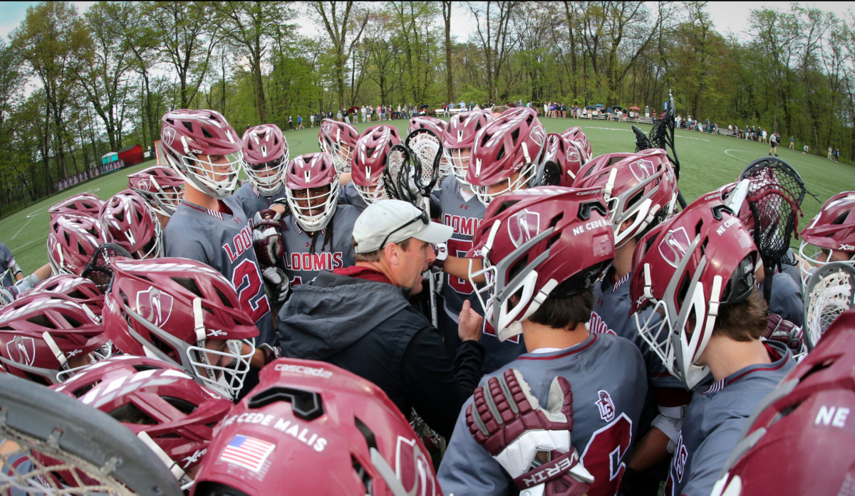 Coach Ball huddles with the Varsity Lacrosse team during Andover game. 